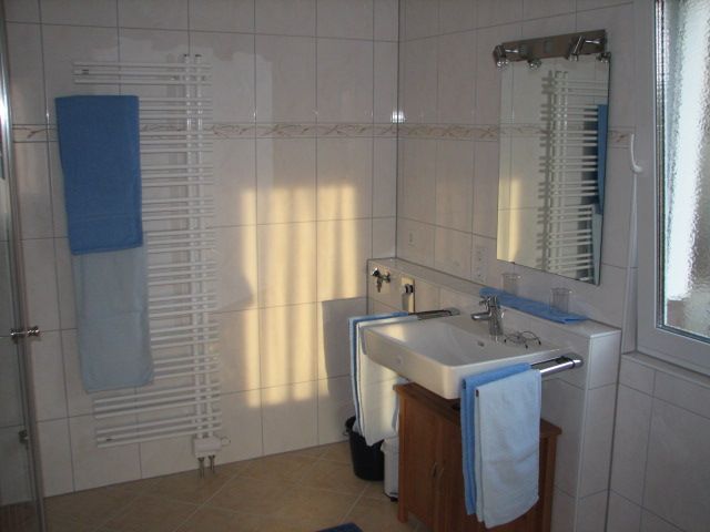 Barrierefreies Badezimmer mit Waschbecken, Spiegel und Handtuchheizkörper